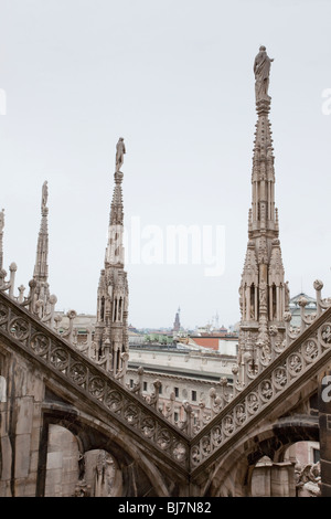 Die komplizierten gotischen Türme des Mailänder Doms (Duomo di Milano) erheben sich über der Stadt, eingerahmt von kunstvollen Steinmetzwerken. Stockfoto