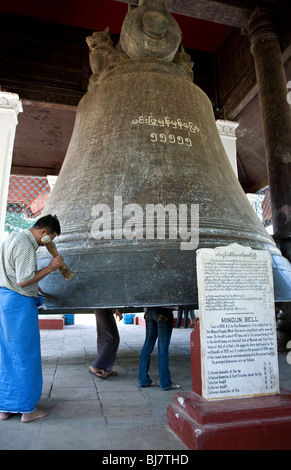 Burmesische Mann pochen die riesigen Mingun Bell. Mingun (in der Nähe von Mandalay). Myanmar Stockfoto