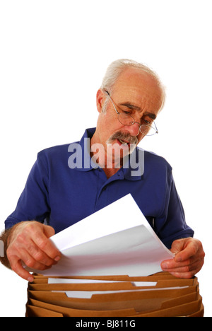 Ältere Mann aussortieren Rechnungen und Papier ans Werk Stockfoto