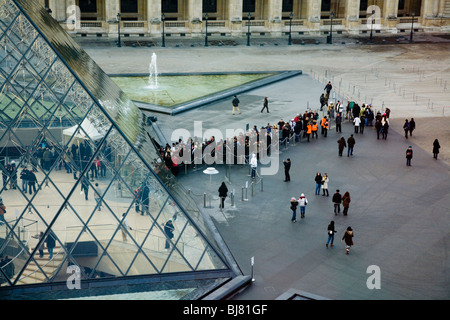 Menschen in die Warteschlange zum kostenlosen Eintritt in das Louvre Museum / Musée / Palais du Louvre, neben der Glaspyramide. Paris, Frankreich. Stockfoto