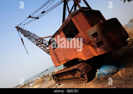 Indien, Kerala, Mahe (Pondicherry) Unionsterritorium, alten rostigen Kran auf felsige Wellenbrecher Küstenschutz Stockfoto