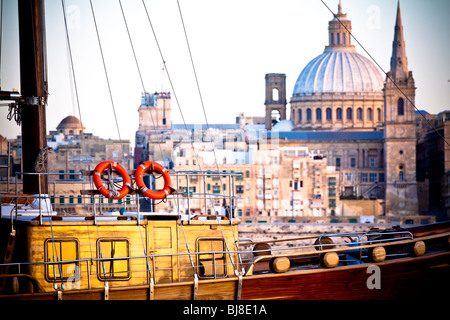 Segelschiff bei Sonnenuntergang vor der Skyline von Valletta, Malta Stockfoto