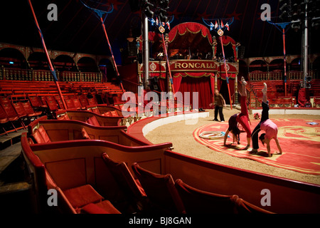 Zwischen den Shows trainieren, zwei junge Mädchen um Turnerinnen unter der Aufsicht eines Trainers. Zirkus Roncalli. München, Deutschland Stockfoto