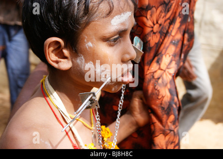 Ein kleiner Junge, Teilnahme an Kavadi (Kaavadi, Kavady) Tempelfest in Kerala. Eisenstange (Speer) ist über seine Wangen durchbohrt. Stockfoto