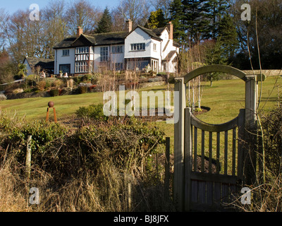 Cheshire, Mottram St Andrew, schönes Einfamilienhaus mit Garten schräg auf Holztor Stockfoto