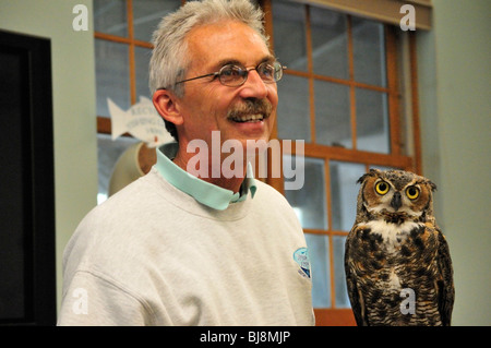 Große gehörnte Eule (Bubo Virginianus) mit Naturforscher Michael Brothers am Marince Science Center in Ponce Inlet, Florida Stockfoto