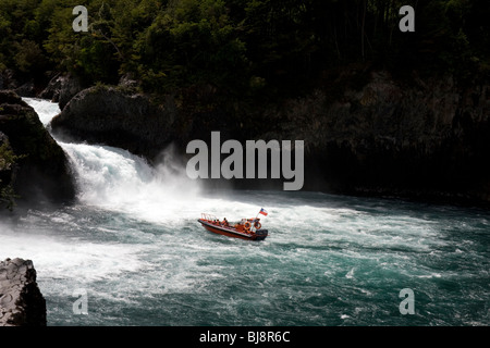 Ein Touristenboot nimmt einen genaueren Blick auf Petrohue Wasserfälle, Chile, Südamerika. Stockfoto