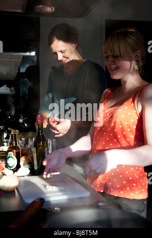 Zwei junge Frauen, die gemeinsam am Kochen zu Hause, in der Küche Stockfoto