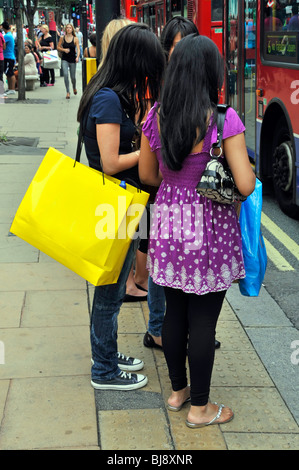 Frau, die trägt einer gelbe Tragetasche in Oxford Street Selfridges Namen Digital aus gelben Beutel entfernt siehe auch Alamy BJ8XNR Stockfoto