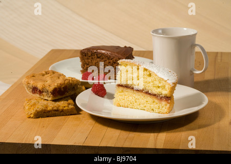 Scheiben von verschiedenen Kuchen auf weißen Platten Stockfoto