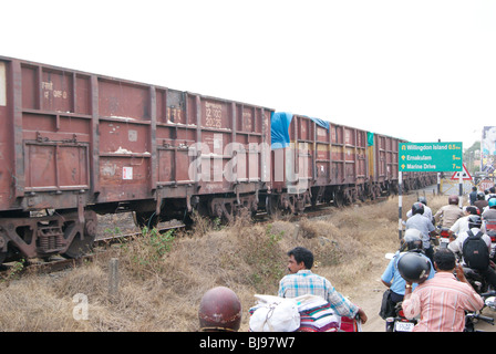 Ware Zug bestehen über die Rail Road Cross und Schwerverkehr Block auftreten, in der Nähe Bahnhof Tor. Szene aus Cochin Kerala Indien Stockfoto