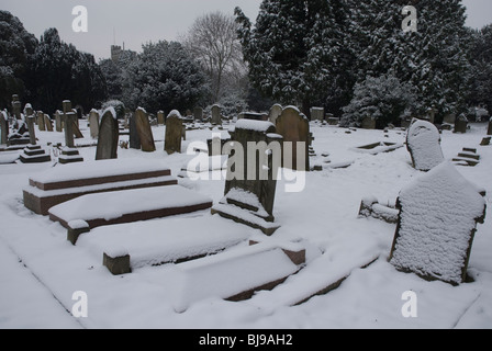 St Leonards Friedhof mit Grabsteinen schneebedeckt, Heston West London, UK Stockfoto