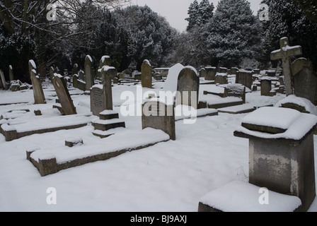 St Leonards Friedhof mit Grabsteinen schneebedeckt, Heston West London, UK Stockfoto