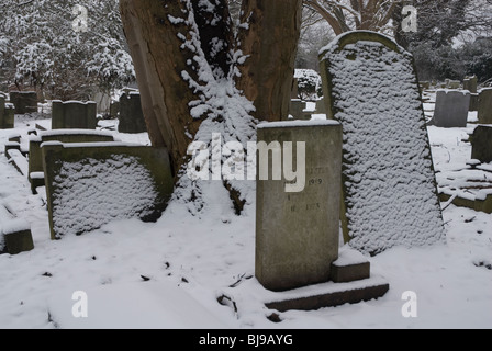 St Leonards Friedhof mit Grabsteinen schneebedeckt, Heston West London, UK Stockfoto