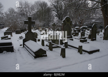 St Leonards Friedhof mit Grabsteinen schneebedeckt, Heston West London, UK Stockfoto