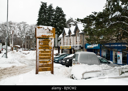 dh AVIEMORE INVERNESSSHIRE Wintersport Schnee bedeckten Shop Wegweiser und Geschäfte Stockfoto