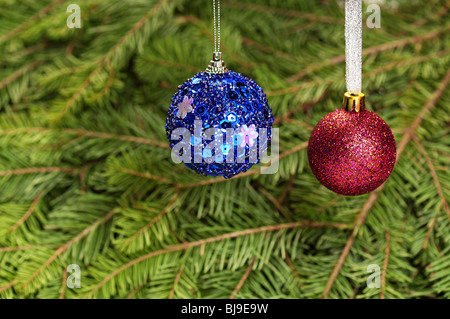 Weihnachtskugeln über Fell Baum Zweige Hintergrund Stockfoto