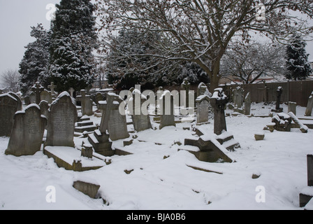 St Leonards Friedhof mit Grabsteinen schneebedeckt, Heston West London, UK Stockfoto