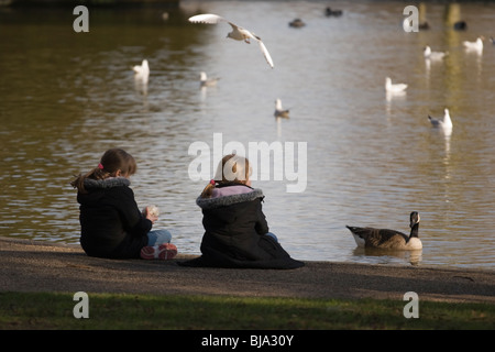 Zwei Kinder füttern die Enten in einem park Stockfoto