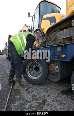 Ein Reifen Fitter arbeiten auf einem LKW-Reifen am Straßenrand geändert wird Stockfoto