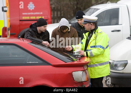 Ein Polizist überprüfen und im Gespräch mit ausländischen Autofahrer bei gemeinsamen VOSA und Polizei-checkpoint Stockfoto