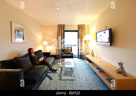 Eine Frau liest eine Zeitschrift in einem Hotelzimmer zu genießen. Stockfoto