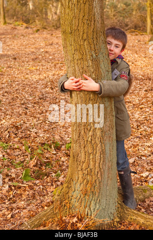 Ein MODEL Release Bild eines 10 Jahre alten Jungen umarmt einen Baum in einem Uk-Holz Stockfoto