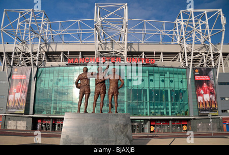 Die Statue, die Sir Bobby Charlton, George Best Denis Law am Haupteingang (East Stand) in Old Trafford, Manchester. Stockfoto