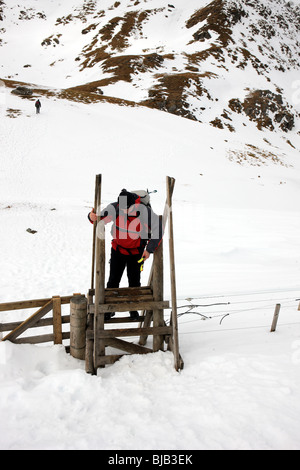 Walker ein Elektrozaun auf Meall Nan Tarmachan einen Stil Überklettern Stockfoto