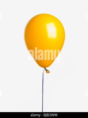 gelber Ballon mit Band auf weißem Hintergrund Stockfoto
