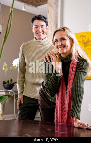 Interracial Paar mittleren Erwachsenenalter stehen zusammen zu Hause tragen Pullover Stockfoto