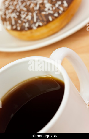 Tasse schwarzen Kaffee und Krapfen in abstrakte Makro Nahaufnahme Stockfoto