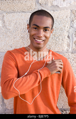 Schöne stilvolle afro-amerikanische Jüngling anhören von Musik Stockfoto