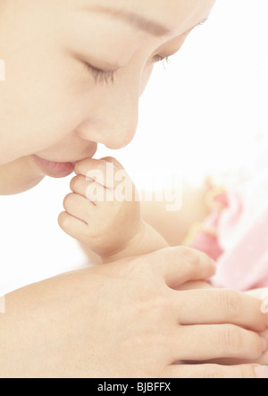 Mutter küssen Baby hand Stockfoto