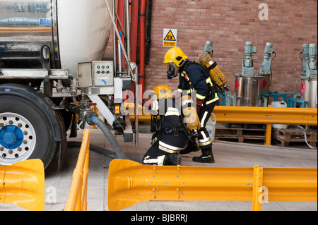 Feuerwehr in Breathing Apparatus suchen Leck stammen aus undichten Chemikalientanker Stockfoto