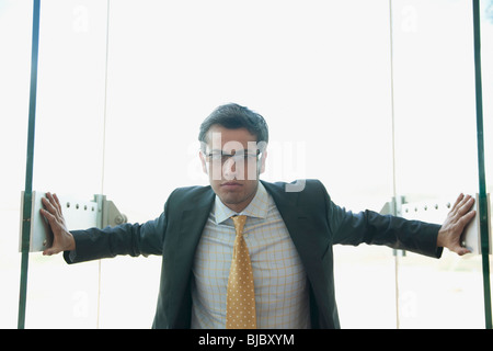 Stirnrunzelnd Hispanic Geschäftsmann öffnen Türen Stockfoto