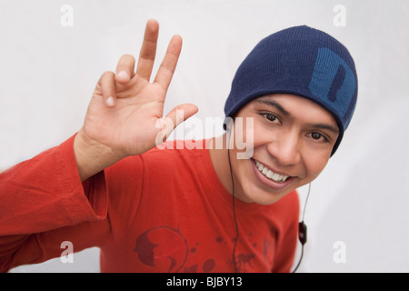 Hispanic Mann in GAP Kopfhörer anhören und winken Stockfoto