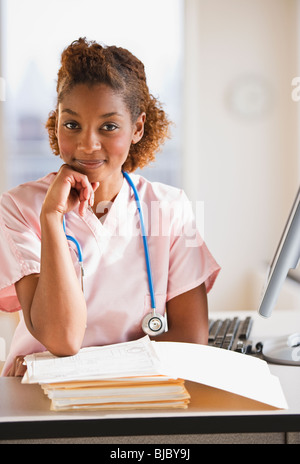 Gemischte Rassen Krankenschwester an medizinischen Diagrammen arbeiten Stockfoto