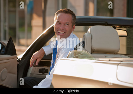 Kaukasische Geschäftsmann lächelnd in Cabrio Stockfoto