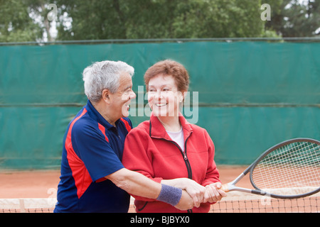 Senior-Hispanic Mann lehrt Frau, Tennis zu spielen Stockfoto