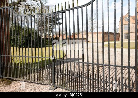 große geschlossene und Vorhängeschloss Tore zum Gelände eines großen Hauses Stockfoto