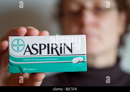 Frau hält eine Schachtel Aspirin hergestellt von deutschen Pharmaunternehmen Bayer Stockfoto