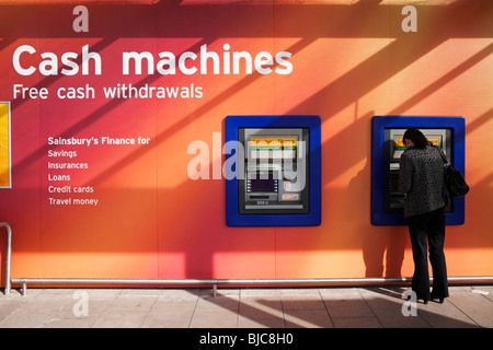 Ein paar Loch in der Wand Geldautomaten außerhalb Sainsbury's Store, Braehead, Renfrewshire, Schottland. Stockfoto