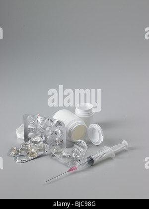 Pharmazeutische Verpackungen zu verschwenden und Spritze mit weißem Kunststoff Tablettenfläschchen in Hochformat und mittlere Ernte gedreht Stockfoto