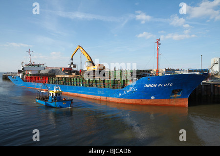 Entladung von einem Schiff für Bretts am Osten Kai. Die Auster Angelboot/Fischerboot "Misty" führt vorbei an einer beliebten Küstenstadt in Kent Stockfoto