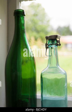 Flaschen, die inmitten einer Fensterbank Stockfoto