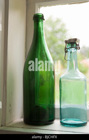 Flaschen, die inmitten einer Fensterbank Stockfoto