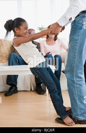 African American Vater mit Tochter im Wohnzimmer tanzen Stockfoto