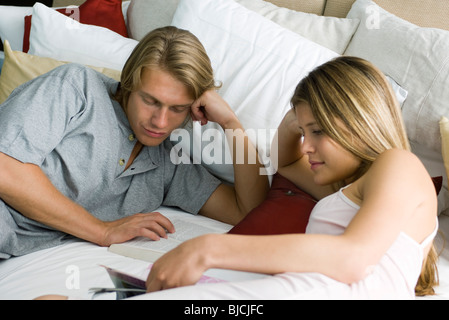 Junges Paar lesen zusammen im Bett Stockfoto