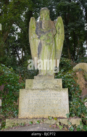 Highgate Cemetery in London, geflügelte Engel mit Kranz für Unsterblichkeit, eingestellt auf 3 Blöcke für glaube, Hoffnung & Nächstenliebe Stockfoto